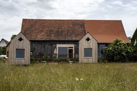 Die Dorfscheune in Bieselsberg, im Vordergrund stehen zwei Tiny-Houses aus Holz